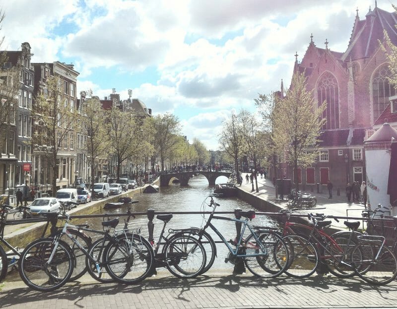 des vélos stationnés contre la rambarde d'un pont à Amsterdam