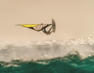 un homme fait un table top en windsurf
