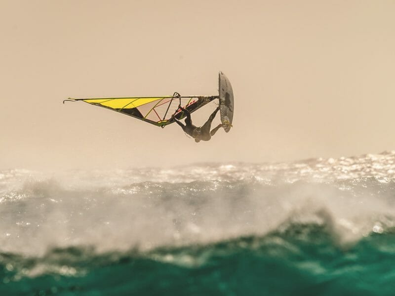 un homme fait un table top en windsurf