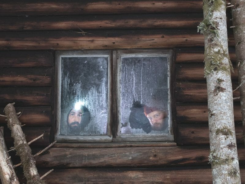 Deux hommes derrière la fenêtre dans une cabane attendent de pouvoir sortir après le confinement dû au coronavirus