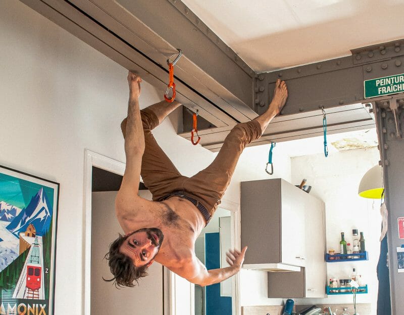 Un homme confiné fait de l'escalade dans la cuisine de son appartement parisien