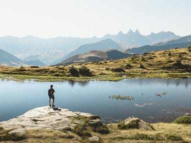 Un homme en rando devant un lac en Savoie Mont Blanc