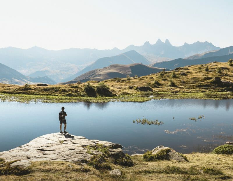 Un homme en rando devant un lac en Savoie Mont Blanc