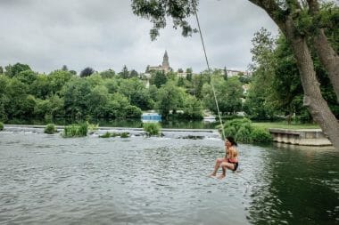une jeune fille plonge dans une rivière