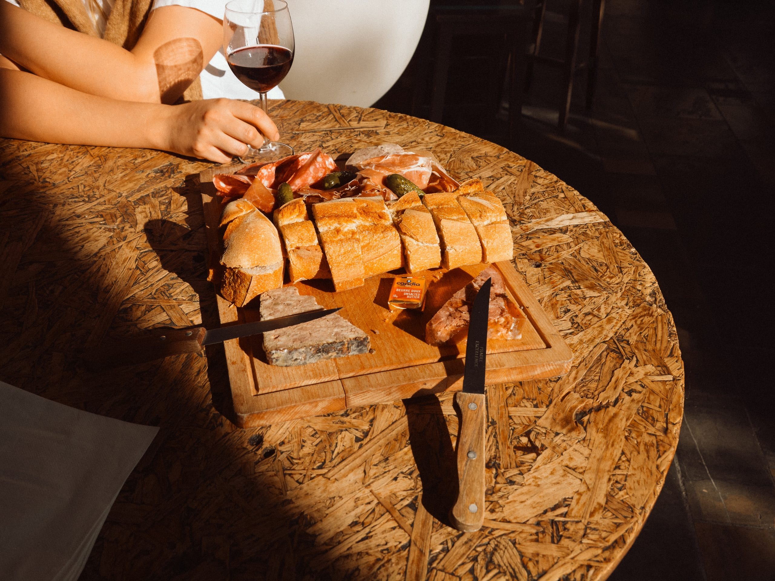 Une planche de charcuterie avec un bon verre de vin