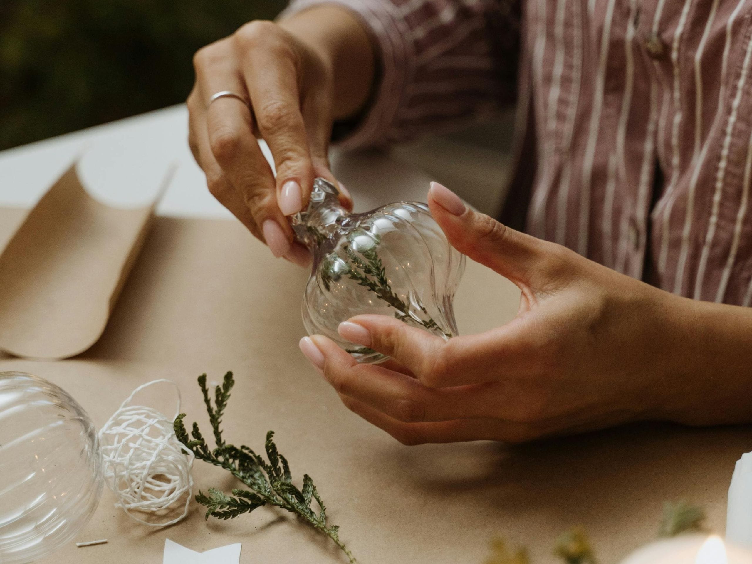 Customisation d'une boule de noël avec des branches de sapin.