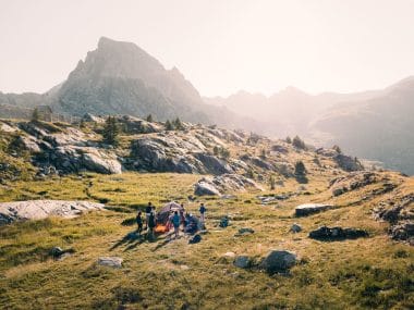 Vue sur la montagne avec un groupe de personnes qui installe leur campement en tente.