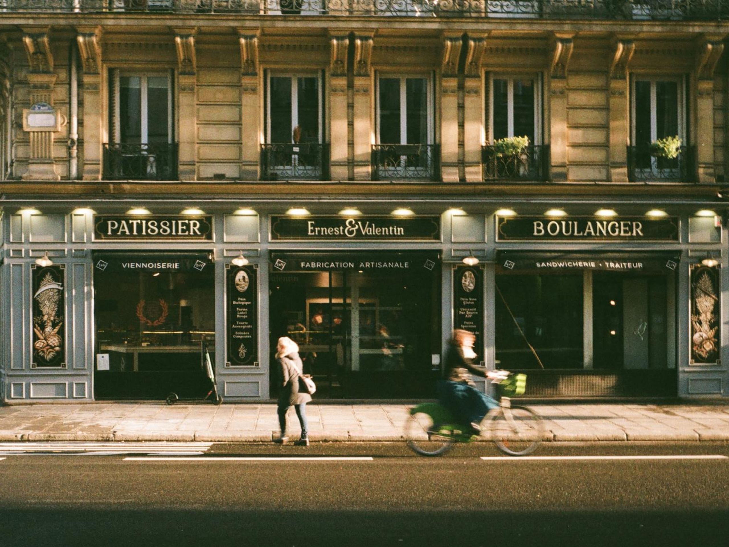 Un vélo qui passe devant une boulangerie à Paris. 