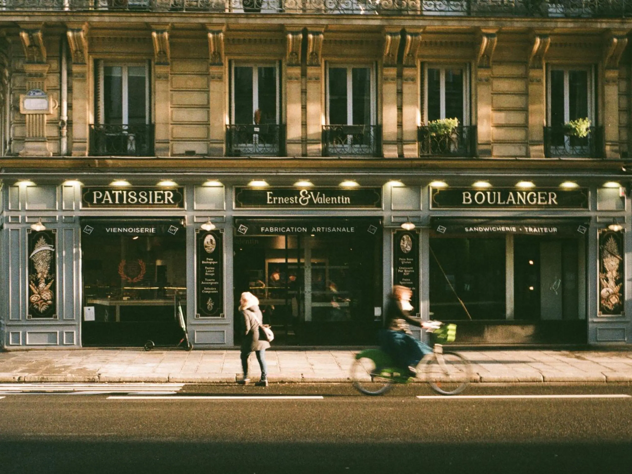 Un vélo qui passe devant une boulangerie à Paris.
