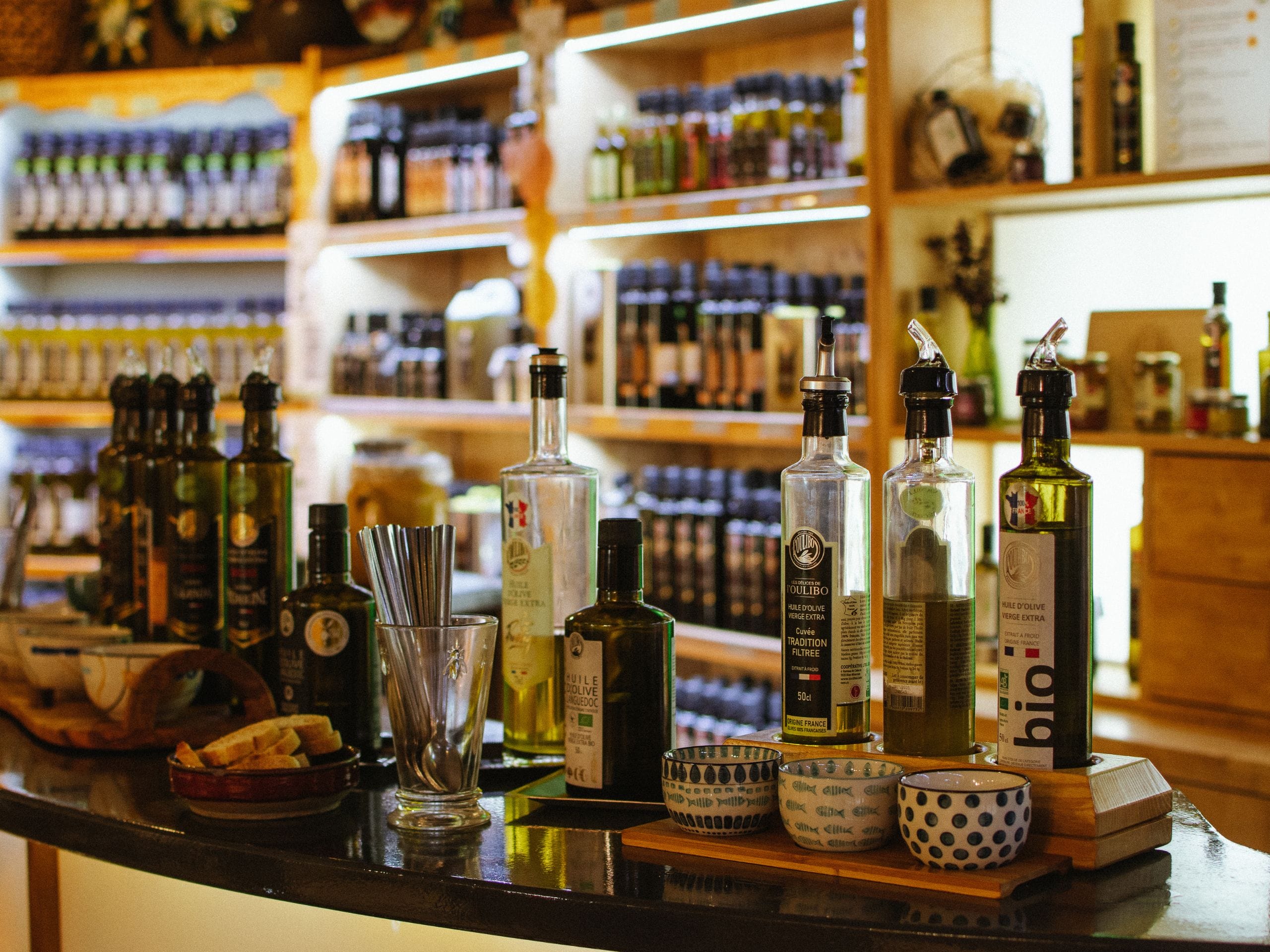 Des bouteilles d'huile d'olive posées sur un bar, prêtes à être dégustées. 