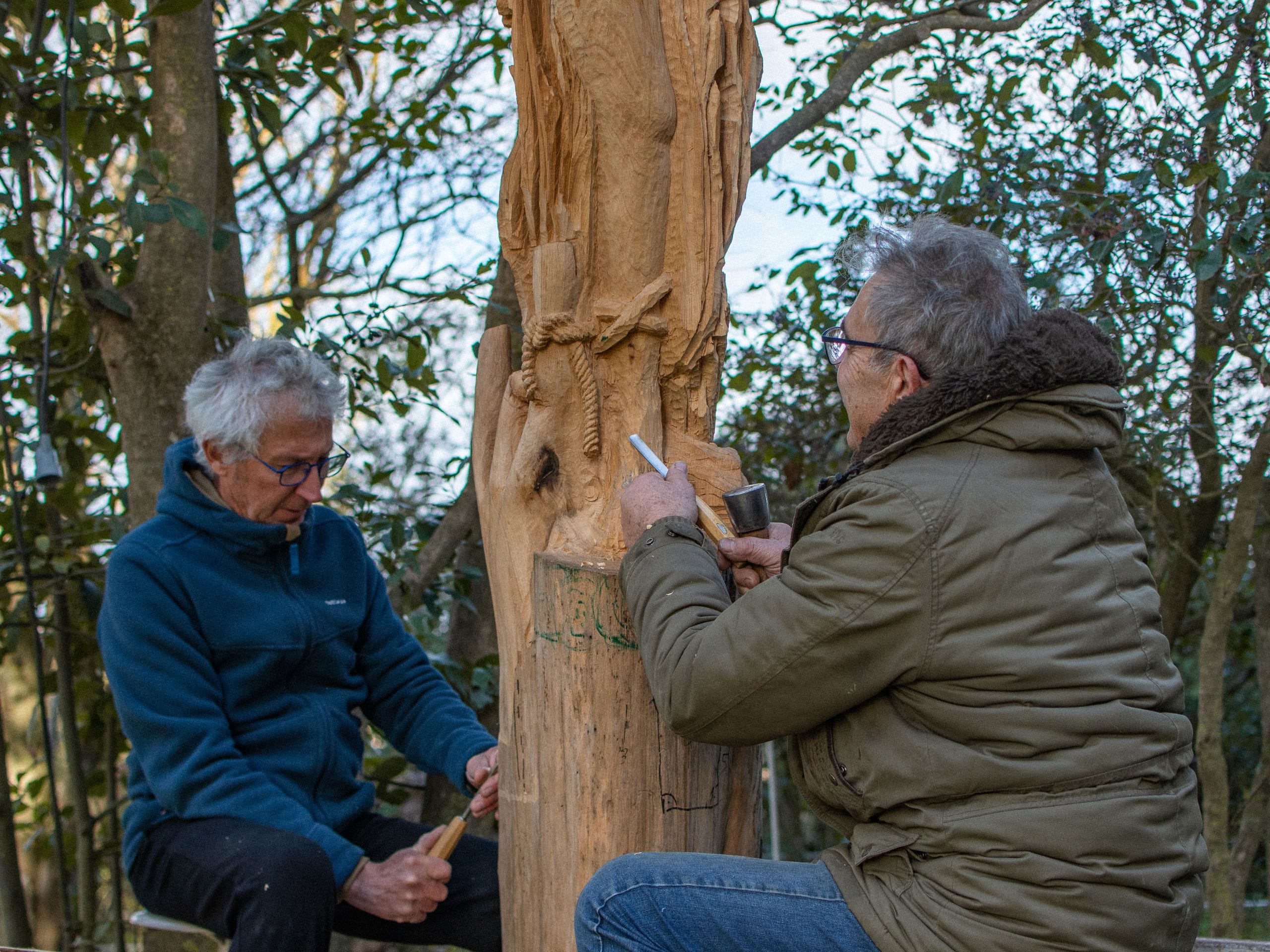 Deux sculpteurs qui donnent naissance à une femme cathare sur un tronc, dans l'Aude. 