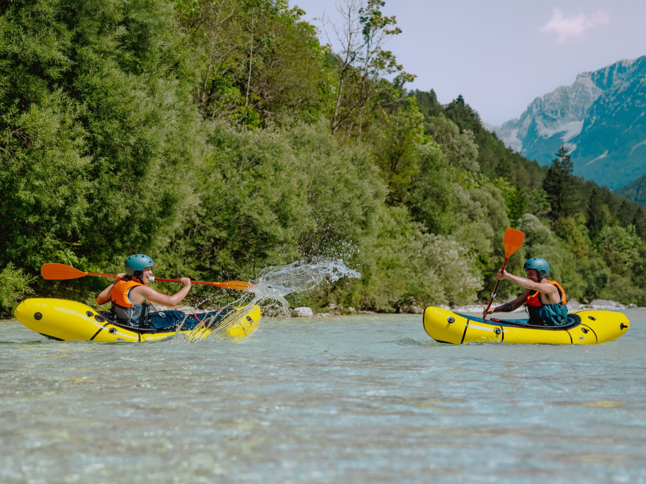 Deux packrafteurs sur la rivière de la Soča qui s'éclaboussent. 