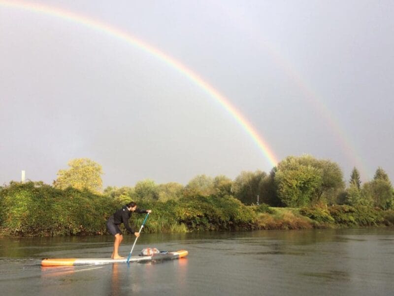 Paddle sur une rivière avec un arc en ciel