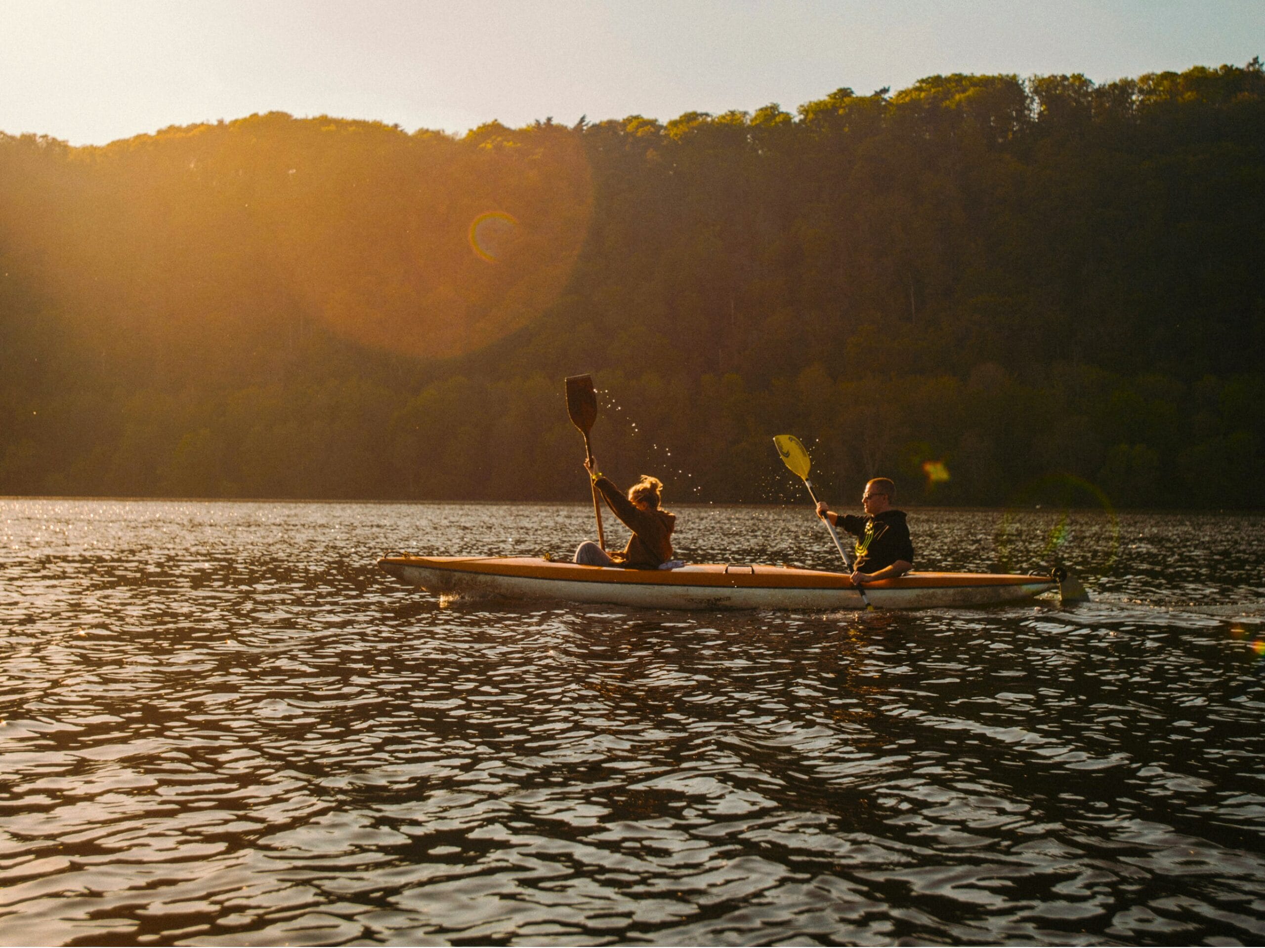 Deux personnes sur un canoë au soleil couchant. 