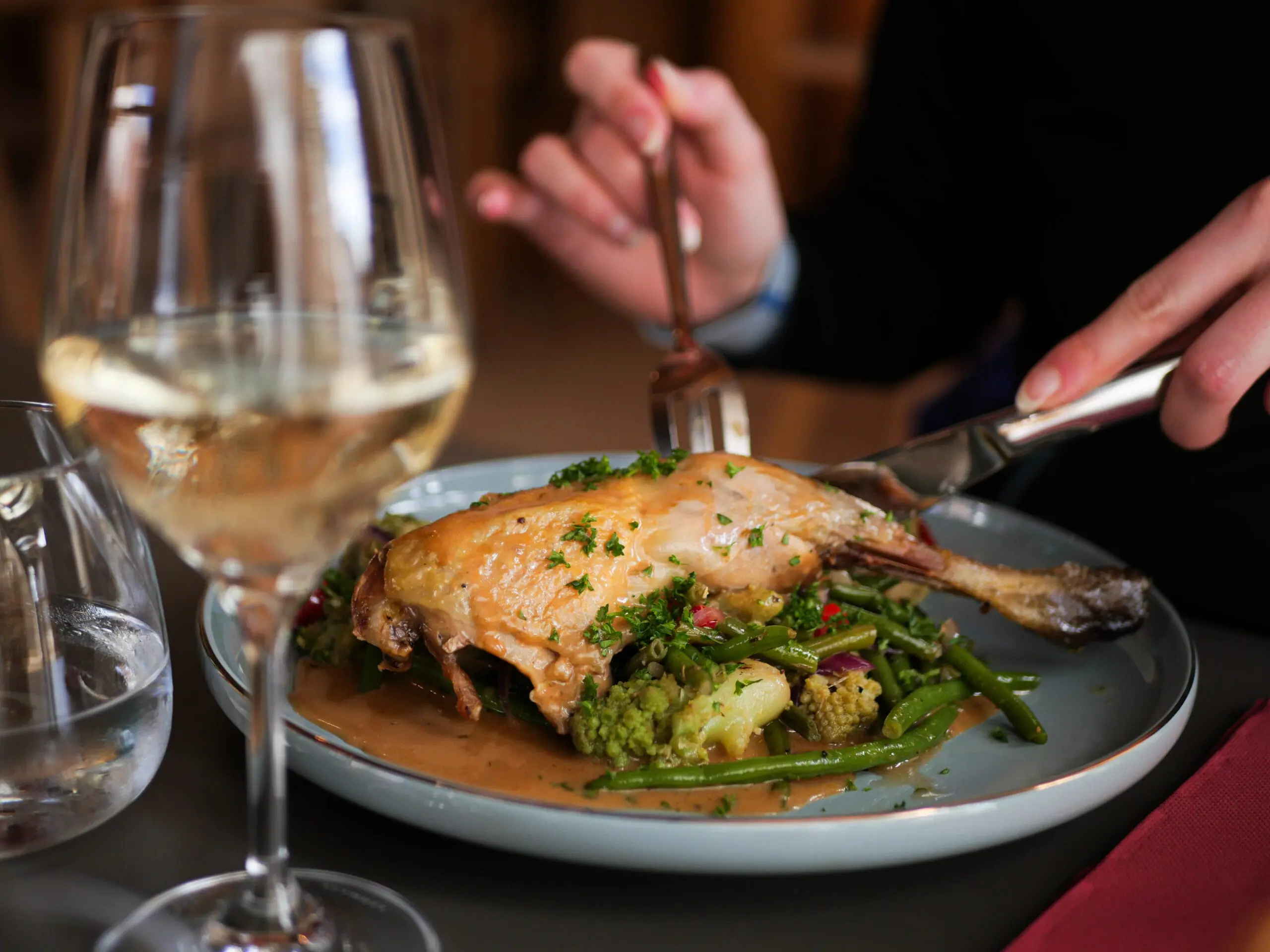 Assiette de pintade avec légumes et un verre de vin