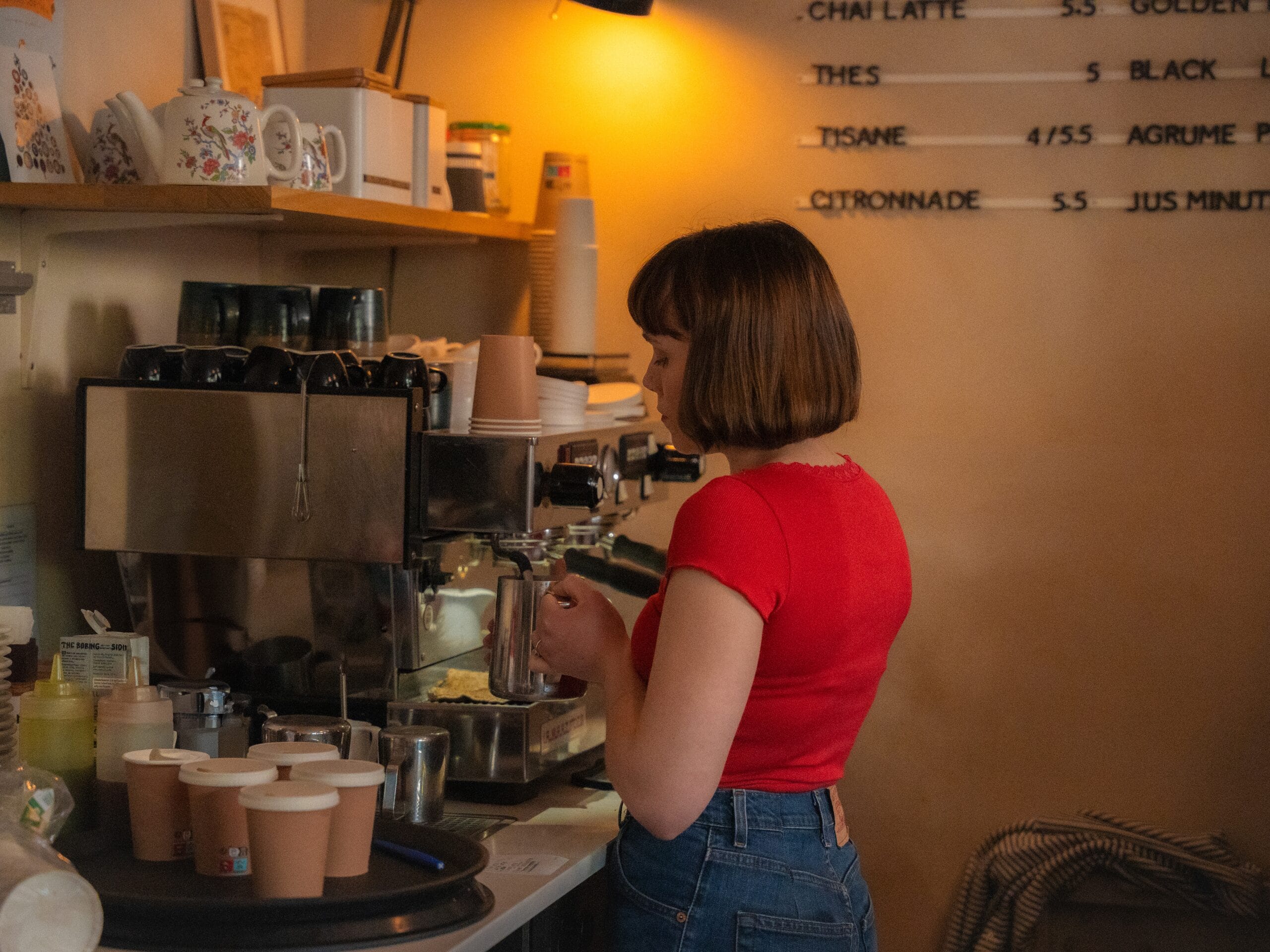 Une jeune femme qui prépare des cafés au Coffee Shop Les 5 marches à Montmartre