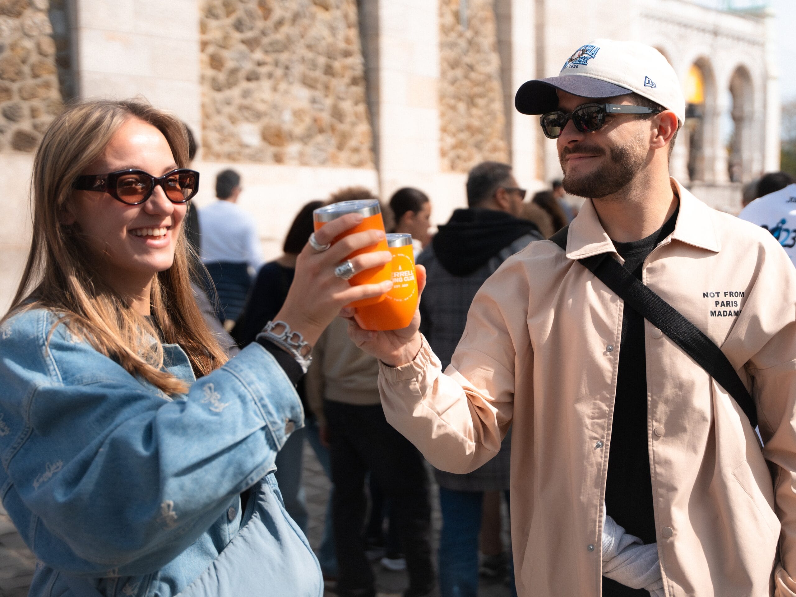Une jeune femme et un homme qui trinque avec une tasse Merrell. 