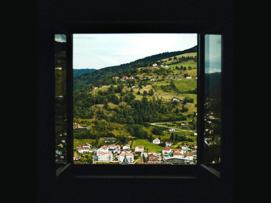 Une fenêtre qui donne sur un village montagneux.