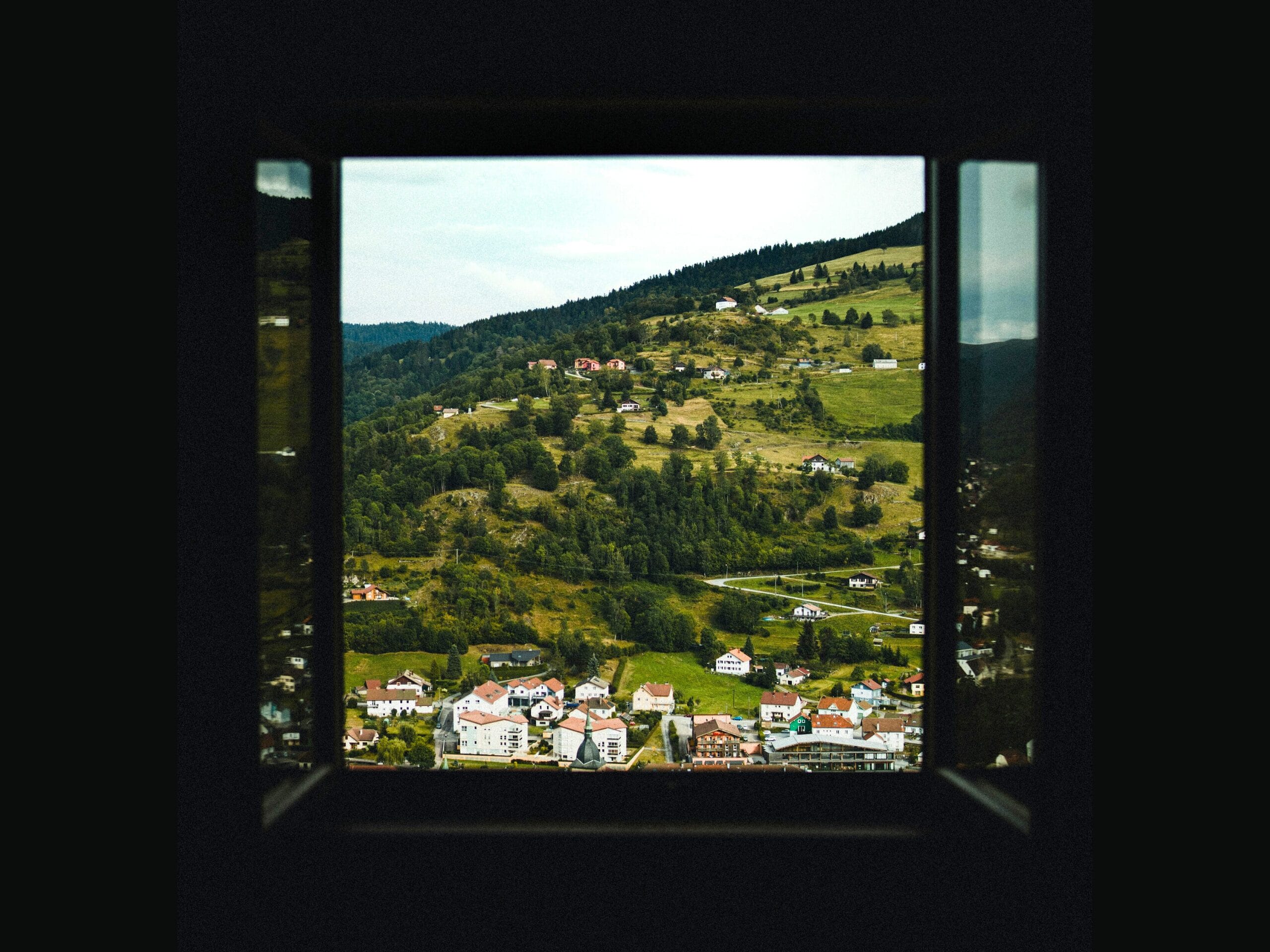 Une fenêtre qui donne sur un village de montagne