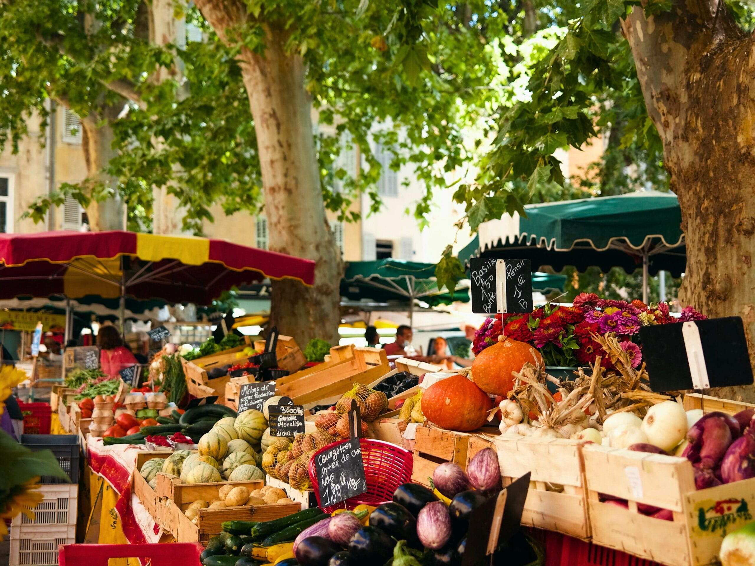 Un marché avec des étalages de fruits et légumes bien colorés