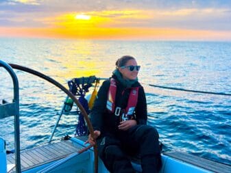 Laura sur son voilier au soleil couchant