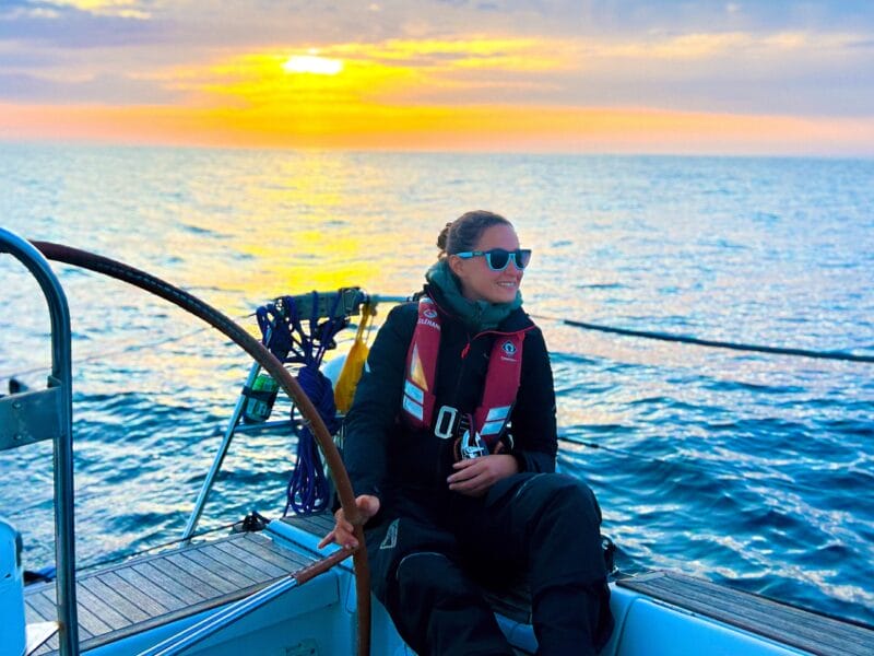 Laura sur son voilier au soleil couchant