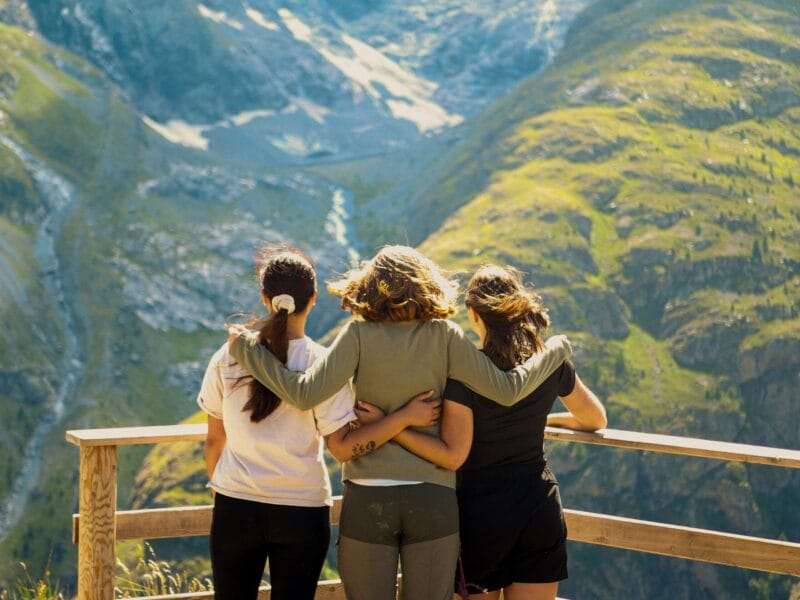 Anémone, Colibri et Alouette de la team Chilowé bras dessus bras dessous face à un paysage de montagne.